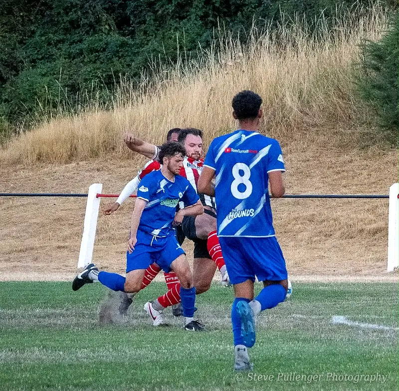 Players challenging for the ball in a local football match
