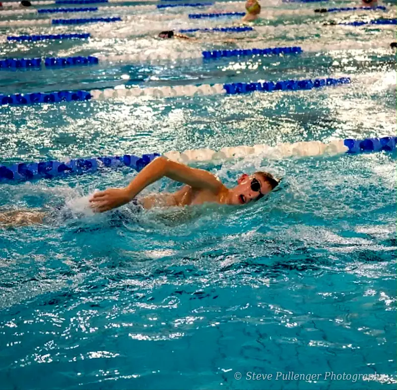 Young swimmer breathing mid-stroke during a freestyle race